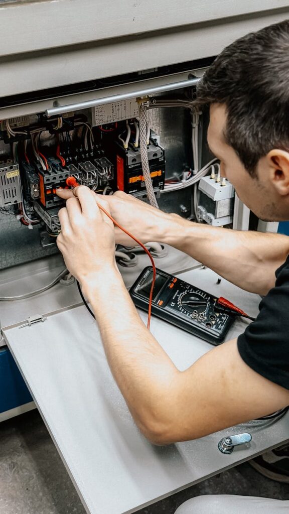 pexels photo 34054464 An electrician uses a multimeter to test and diagnose connections in an open electrical panel.