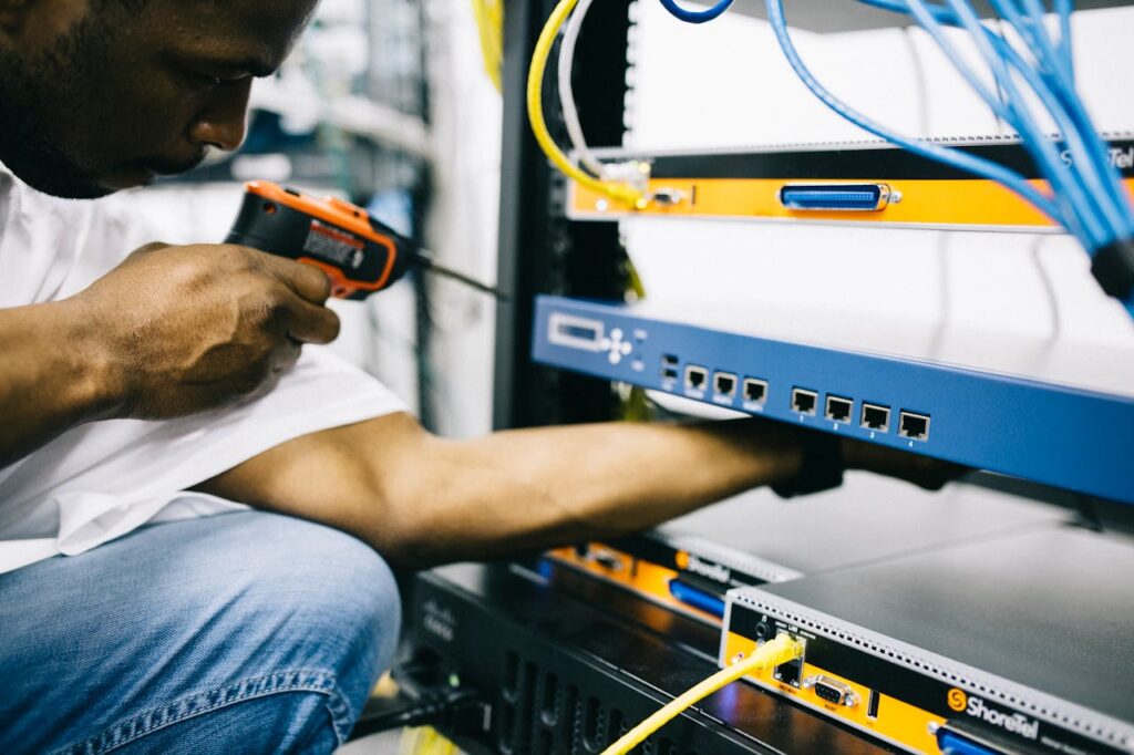 pexels photo 442154 Side view crop concentrate African American male mechanic in jeans and white shirt using screw gun while working with hardware